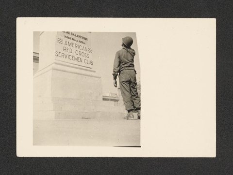 From Nicholas (Mickey) Brecher’s wartime photo album (1942–45): a soldier looks up at a monument carrying the Third Infantry Division’s badge (his division) and